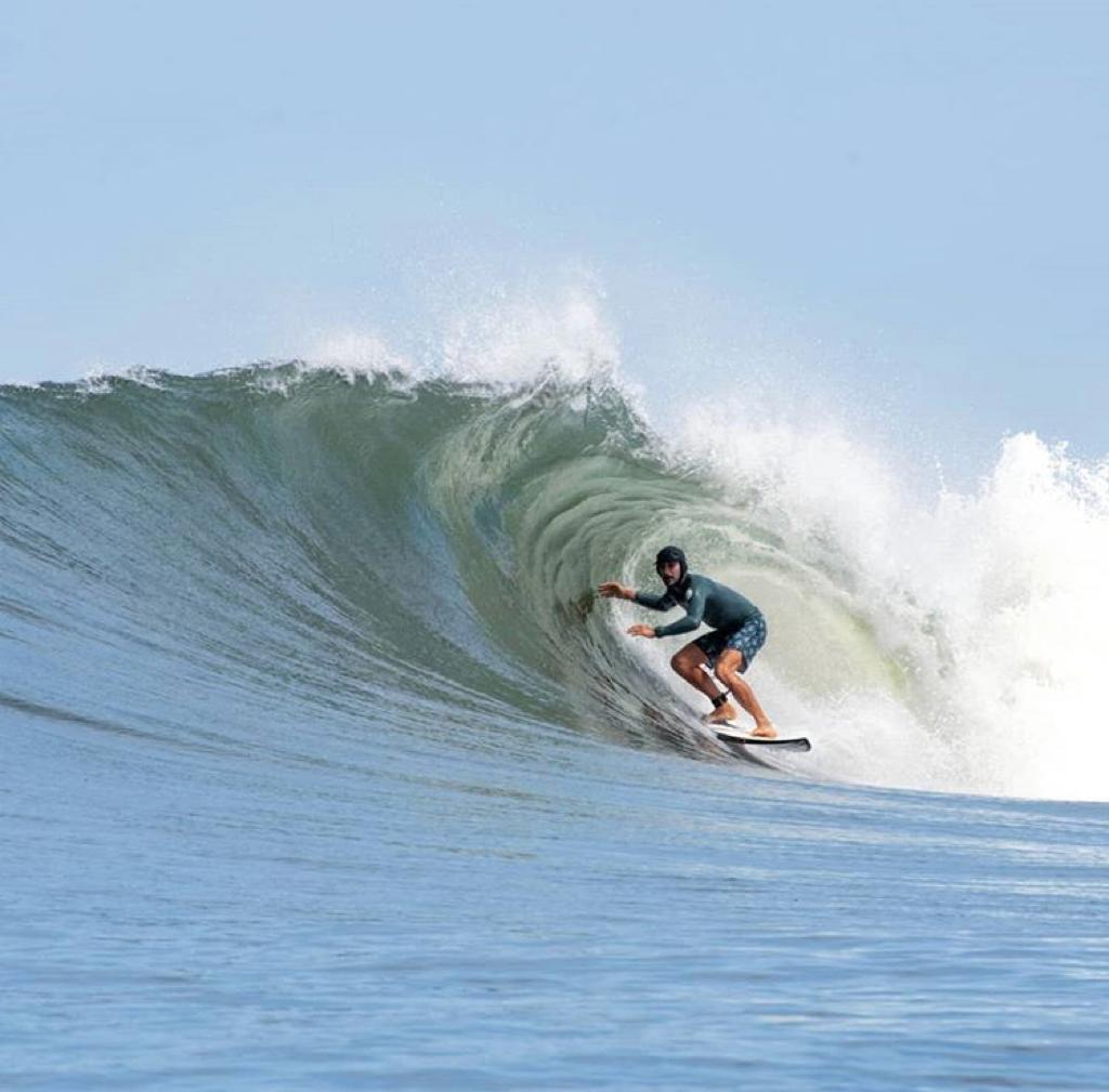 Surfer walking along a Costa Rica beach